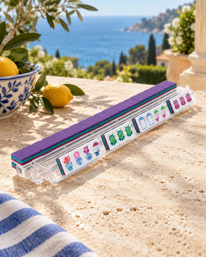 Lavanda Set tiles with plum backs standing in an acrylic rack by the sea