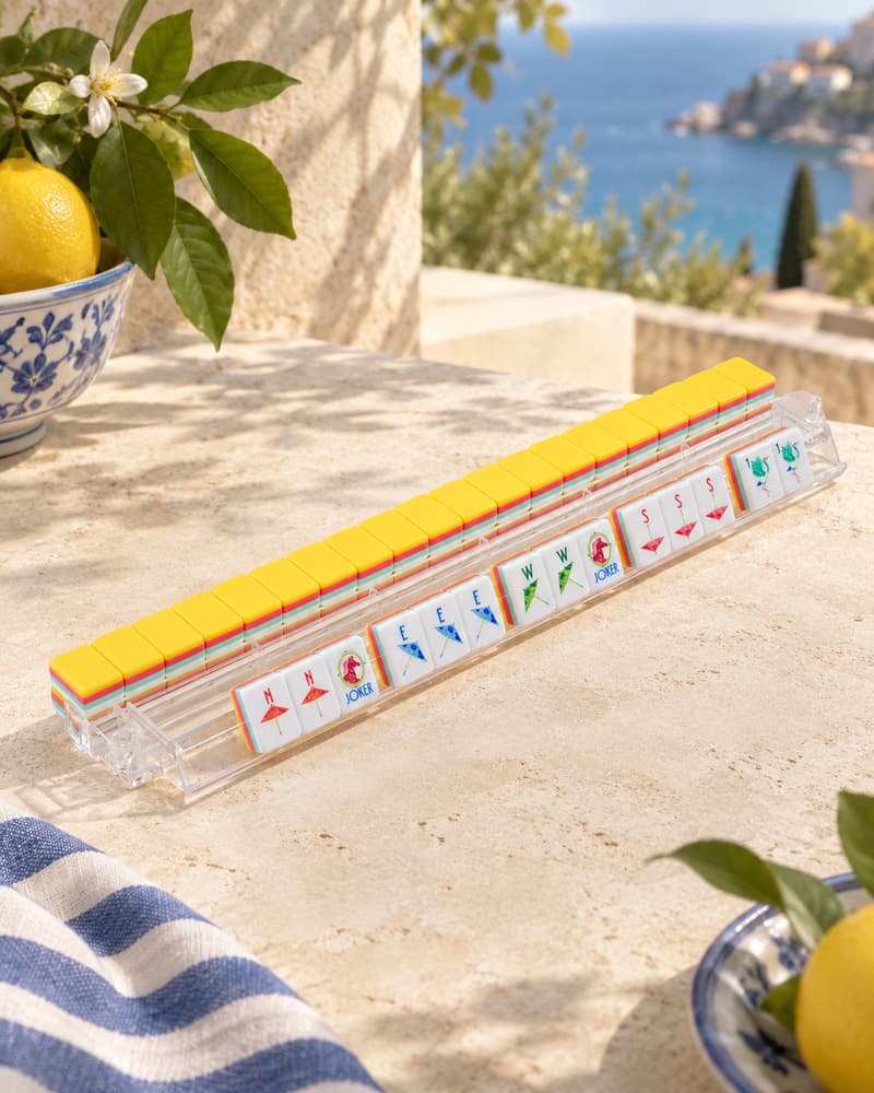 Limone Set tiles with yellow backs standing in an acrylic rack by the sea