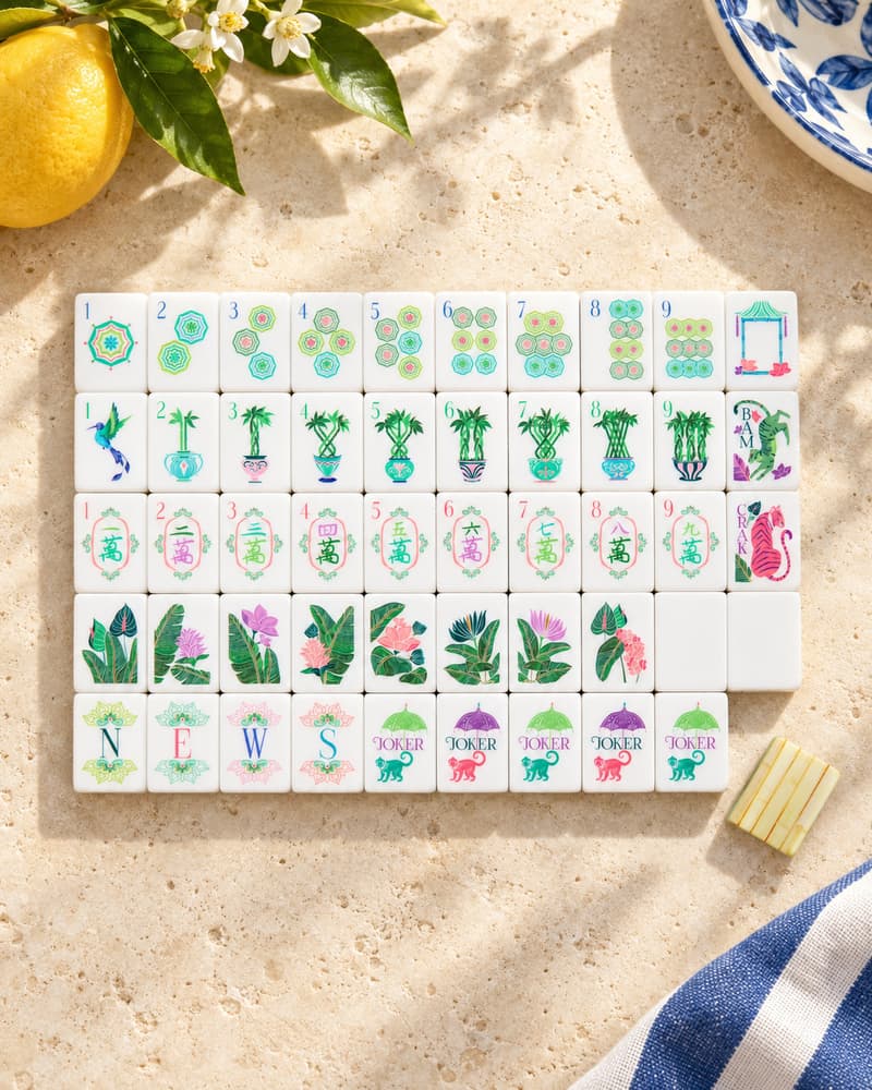 The Palm Grove Set laid out in rows on a sunny stone table, with palm and tropical faces