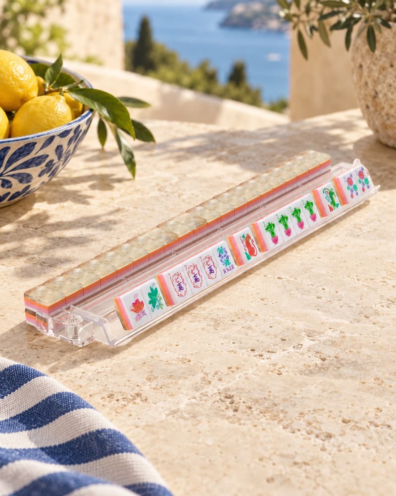 Perla Set tiles with shimmering pearlescent backs standing in an acrylic rack by the sea